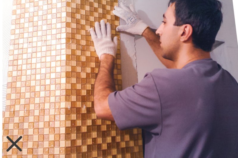 Laying mosaic on the wall