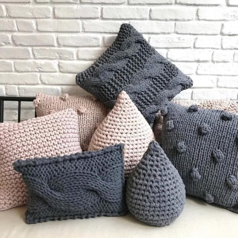 Knitted pillow with knitting needles