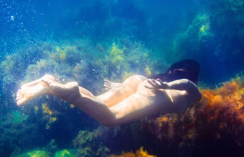 Naked mermaids under water