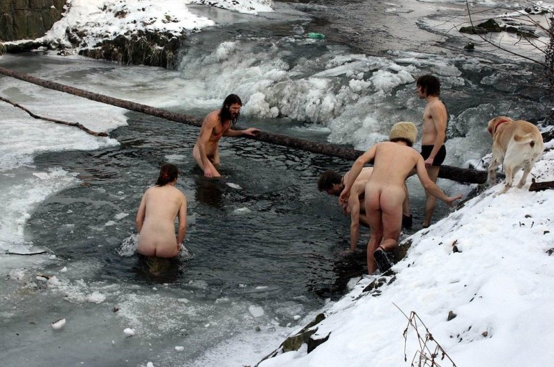 Naked men bathe in an ice hole