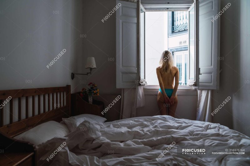 The girl undresses in bedroom