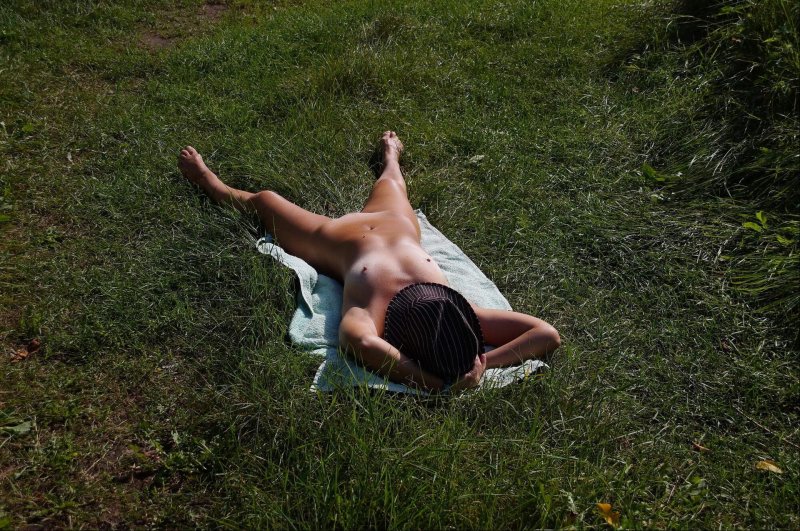 A naked wife sunbathes in nature