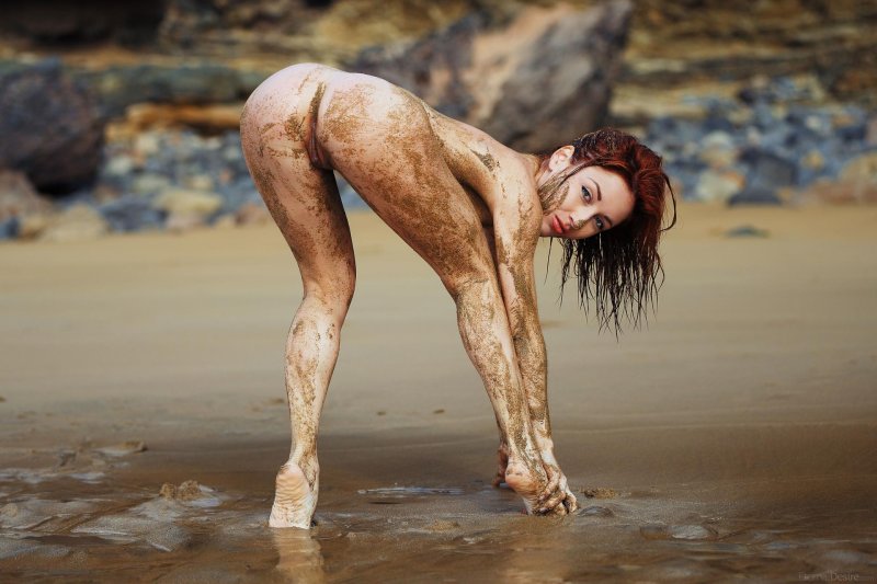Naked women bathe in mud