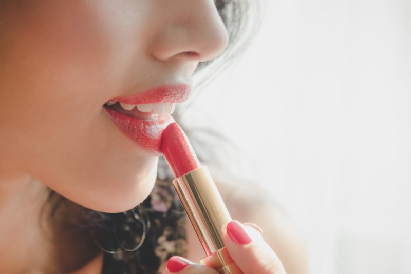 The girl paints lips
