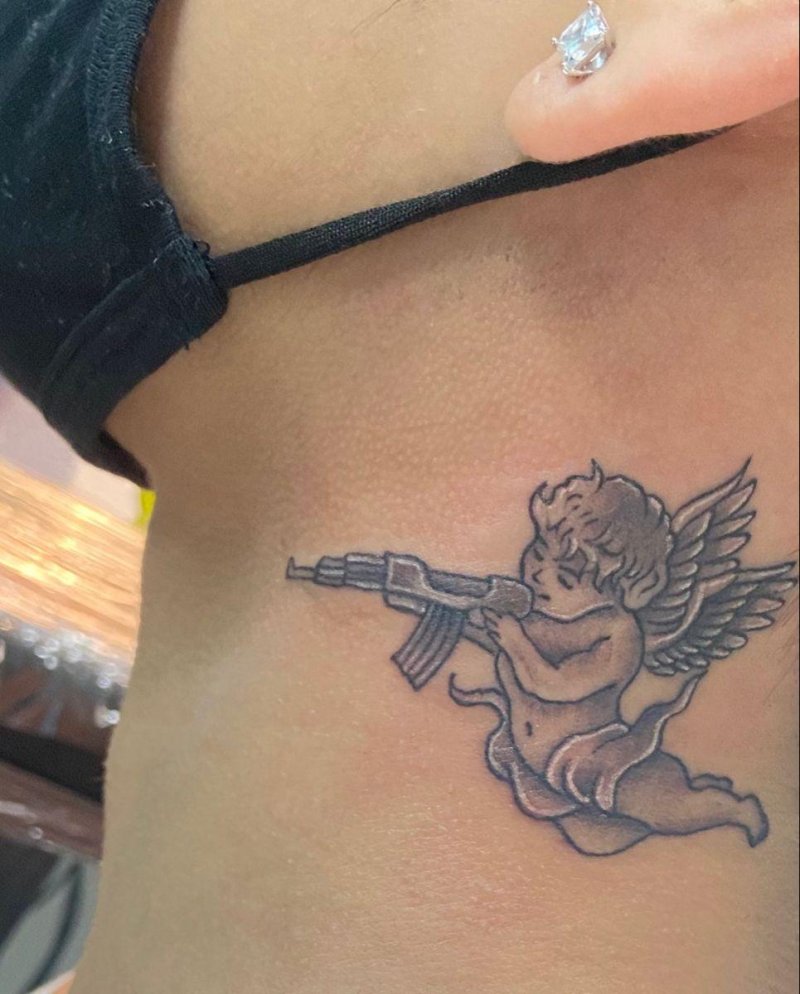 Tattoo angel with a machine gun